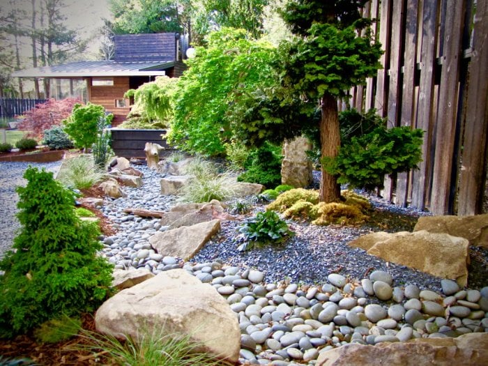Zen-inspired landscape with Japanese trees and rock garden. Zen-inspired landscaping with Japanese trees and rock garden.